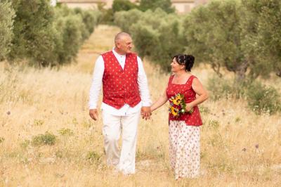 Un couple s'embrasse tendrement dans un cadre naturel entouré de branches d'olivier.