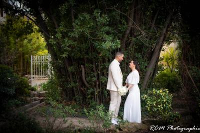 Un couple s'embrasse tendrement dans un cadre naturel entouré de branches d'olivier.
