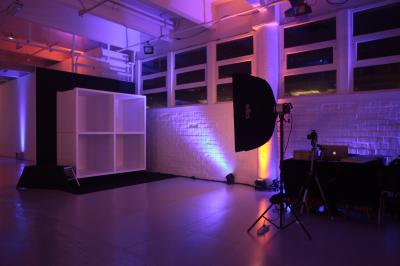 Femme portant des lunettes et un blazer à carreaux, posant devant un fond clair.