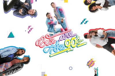 Femme portant des lunettes et un blazer à carreaux, posant devant un fond clair.