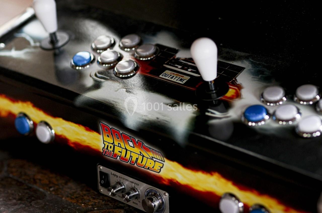 Borne d'arcade rétro personnalisée avec des manettes, boutons et un design inspiré de ’Retour vers le futur’.