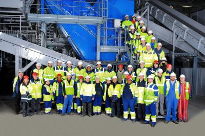 Miniature Freddy Smeets Photographies #3 Un groupe d'adultes posant en extérieur sur une pelouse verte, avec un arbre en arrière-plan.