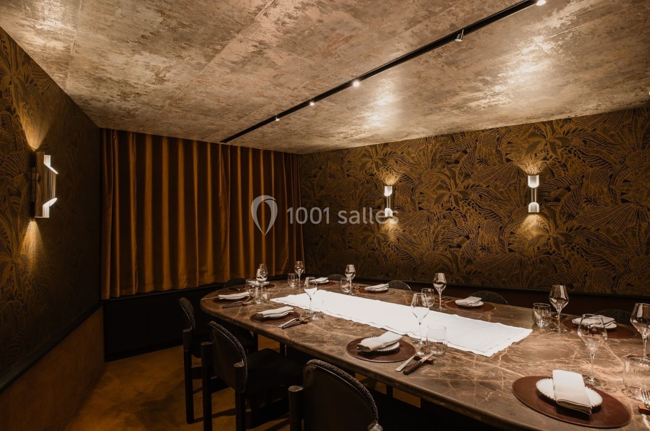 Salle à manger élégante avec table en marbre, chaises noires, vaisselle raffinée et éclairage tamisé.