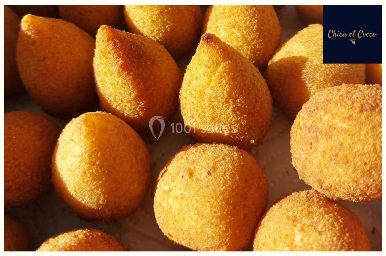 Coxinhas dorées et croustillantes disposées sur une surface claire.