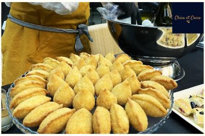 Miniature Traiteur Saint-Germain-en-Laye (Yvelines) - Chica et Cocco #40 Assiette de beignets dorés disposés en cercle sur une table, avec un serveur en arrière-plan.