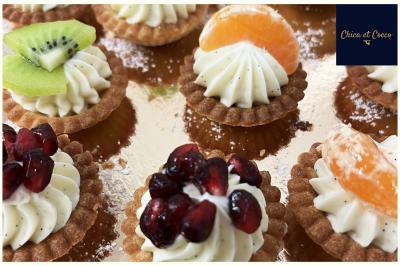 Assiette garnie de beignets dorés en forme de demi-lune, présentée sur une table avec une coupe en arrière-plan.