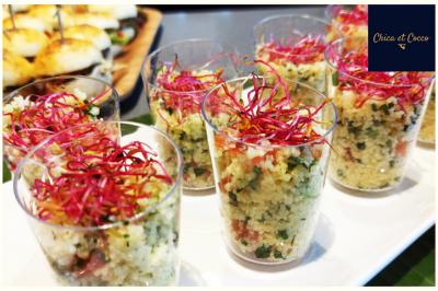 Assiette garnie de beignets dorés en forme de demi-lune, présentée sur une table avec une coupe en arrière-plan.