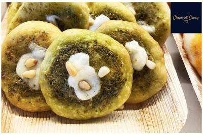 Assiette garnie de beignets dorés en forme de demi-lune, présentée sur une table avec une coupe en arrière-plan.