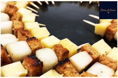 Assiette garnie de beignets dorés en forme de demi-lune, présentée sur une table avec une coupe en arrière-plan.