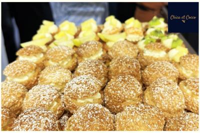 Assiette garnie de beignets dorés en forme de demi-lune, présentée sur une table avec une coupe en arrière-plan.