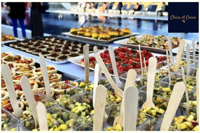 Assiette garnie de beignets dorés en forme de demi-lune, présentée sur une table avec une coupe en arrière-plan.