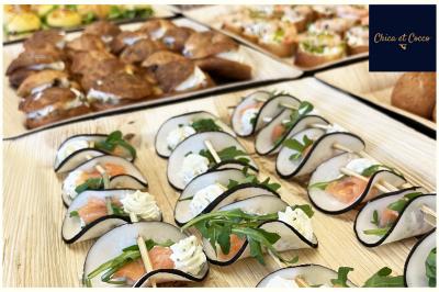 Assiette garnie de beignets dorés en forme de demi-lune, présentée sur une table avec une coupe en arrière-plan.