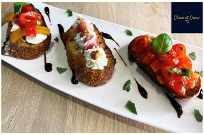 Assiette garnie de beignets dorés en forme de demi-lune, présentée sur une table avec une coupe en arrière-plan.