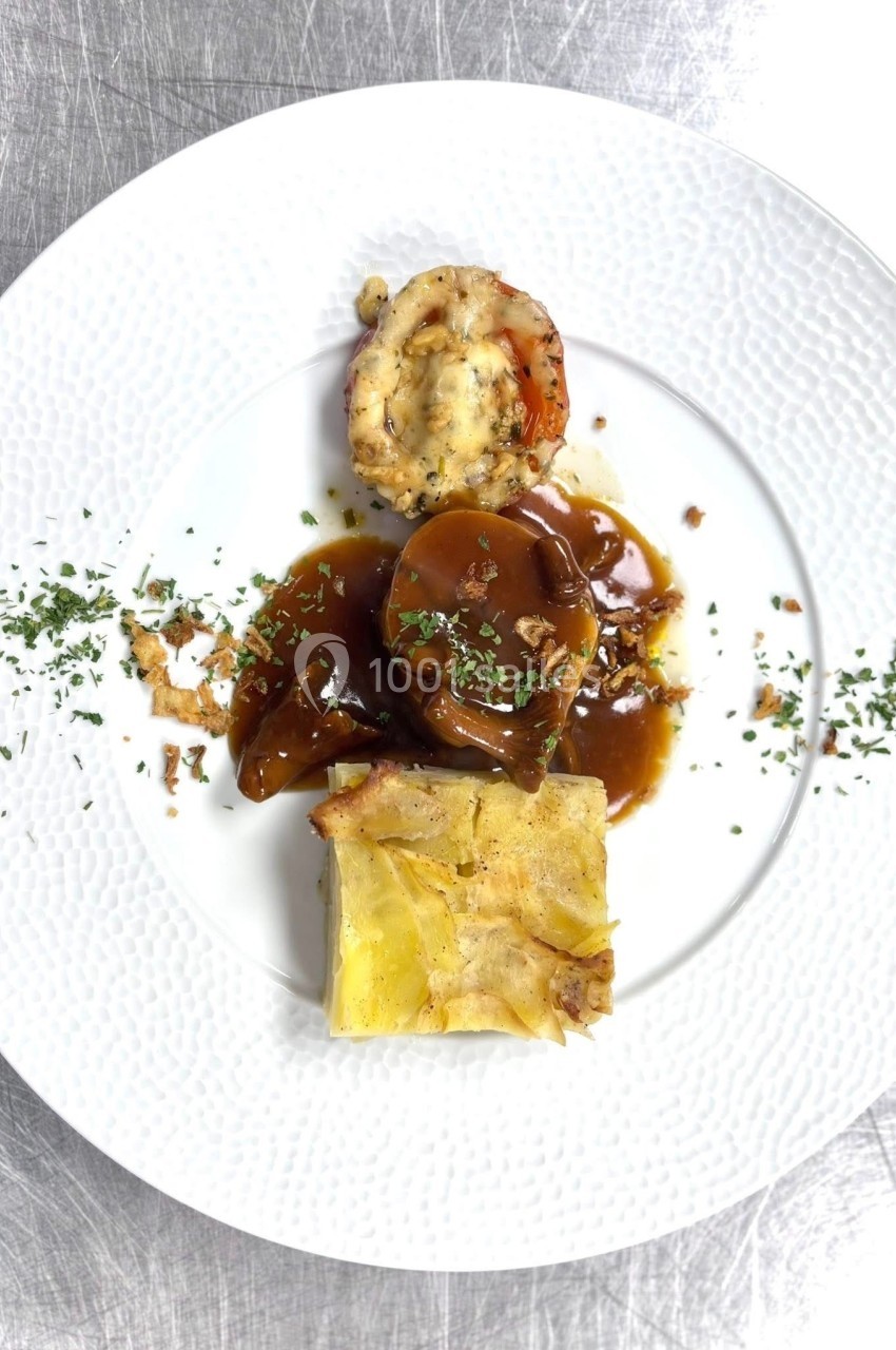 Assiette gastronomique composée de langouste gratinée, pommes de terre fondantes et sauce brune, décorée de persil.