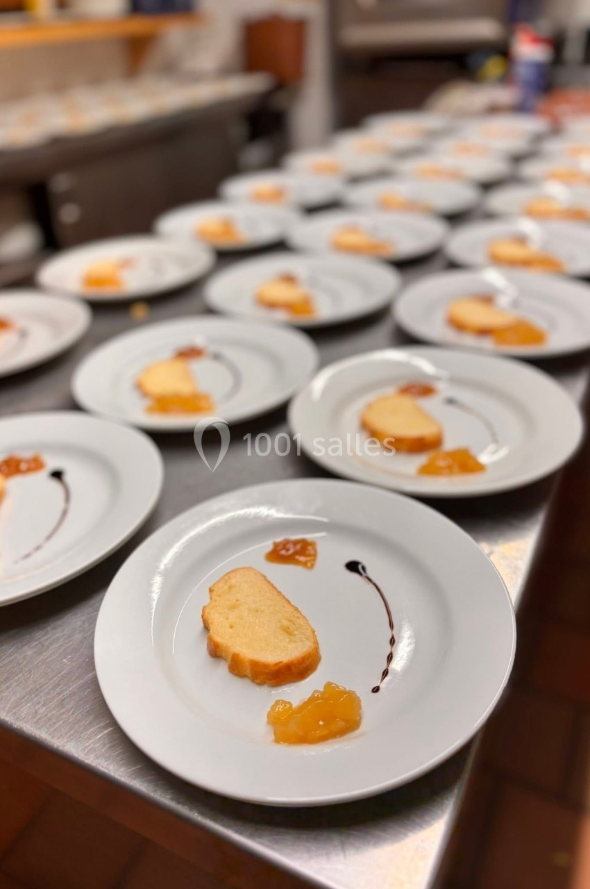 Assiettes alignées contenant une tranche de pain et des condiments, disposées sur un plan de travail en cuisine.