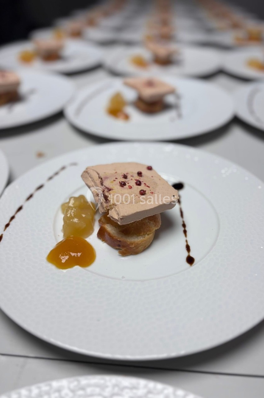 Tranche de foie gras sur pain toasté avec chutney et réduction balsamique, servie sur une assiette blanche.