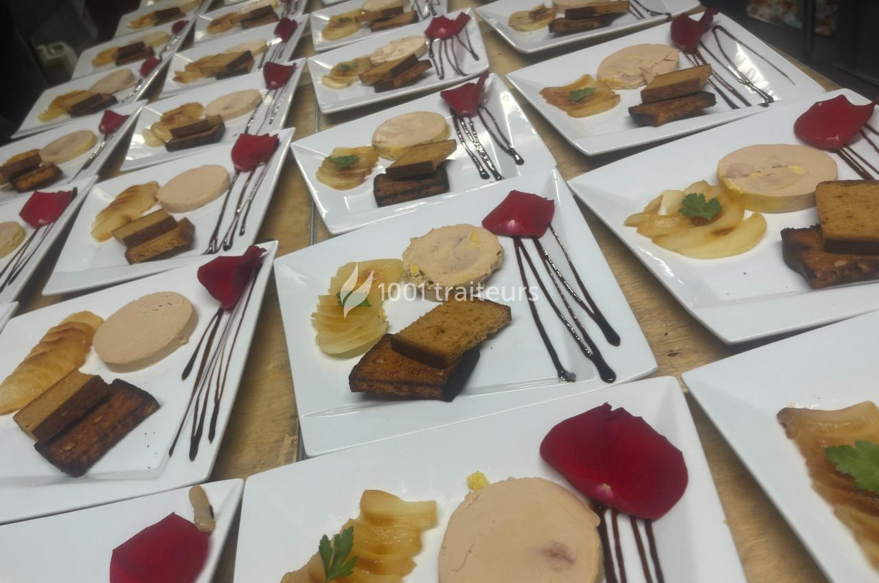 Assiettes dressées avec foie gras, tranches de pain d'épices, pommes, filet de sauce et pétale de rose rouge.
