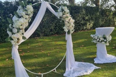 Intérieur d'une église avec bancs en bois, chaire sculptée, lustre central et fresques ornant le chœur.