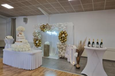 Intérieur d'une église avec bancs en bois, chaire sculptée, lustre central et fresques ornant le chœur.