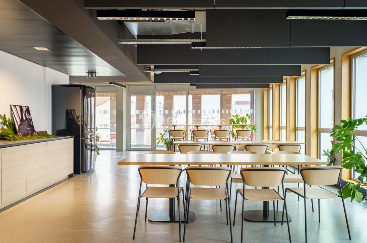 Location salle Ivry-sur-Seine (Val-de-Marne) - Walter Ivry #15 Salle lumineuse avec de grandes fenêtres, tables en bois, chaises assorties et plantes décoratives.
