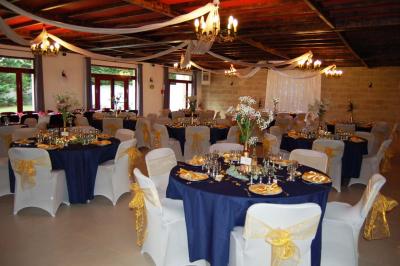 Cuisine professionnelle avec carrelage beige, plans de travail en inox, évier, réfrigérateur et éclairage fluorescent.