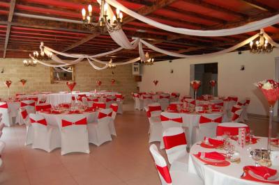 Cuisine professionnelle avec carrelage beige, plans de travail en inox, évier, réfrigérateur et éclairage fluorescent.