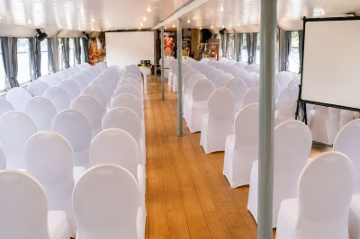 Miniature Location salle Paris 12 (Paris) - La Péniche Croisière de Bercy Corporate #3 Bateau rouge amarré le long d'une berge, entouré d'arbres aux couleurs automnales et sous un ciel dégagé.