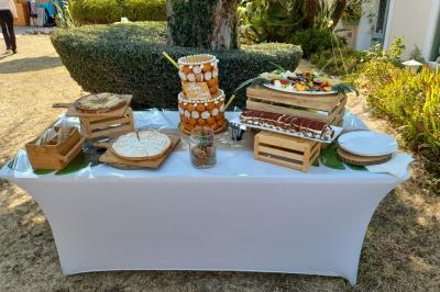 Buffet de salades avec légumes frais, noix, pain tranché et condiments, présenté en extérieur sur une table.