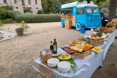 Buffet de salades avec légumes frais, noix, pain tranché et condiments, présenté en extérieur sur une table.