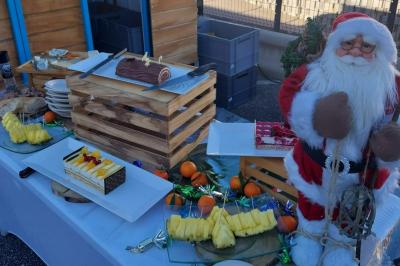 Buffet de salades avec légumes frais, noix, pain tranché et condiments, présenté en extérieur sur une table.