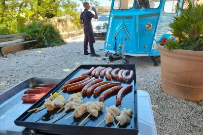 Miniature Traiteur Cannes (Alpes-Maritimes) - Azur Traiteur Events #16 Camion-restaurant bleu vintage devant une concession Mercedes-Benz, avec tables et chaises disposées en terrasse.