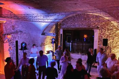 Miniature DJ Istres (Bouches-du-Rhône) - Db Music #5 Salle de réception avec éclairage d'ambiance violet et orange, table centrale éclairée et équipements audio visibles.