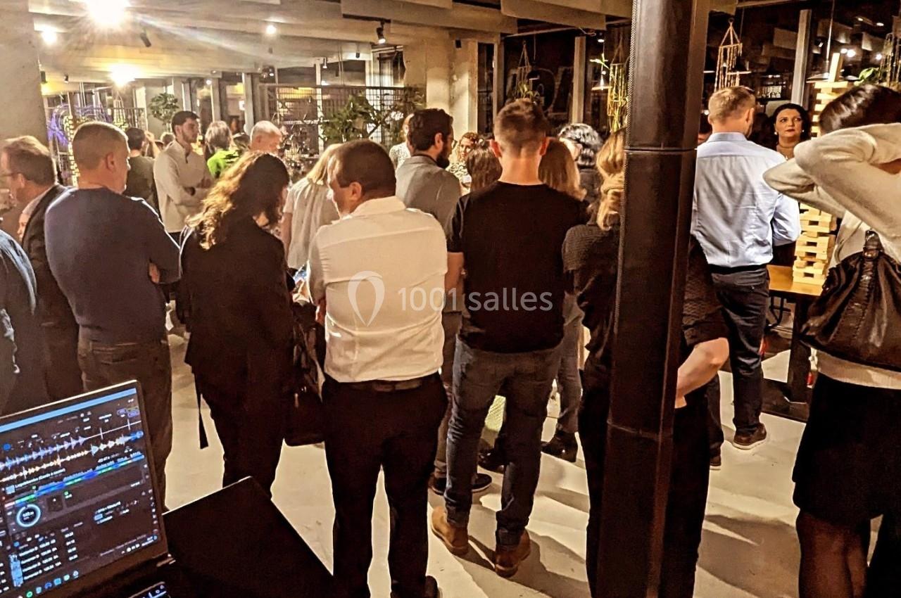 Groupe de personnes debout dans un espace intérieur moderne, lors d'un événement ou d'une réception.