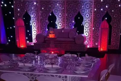 Miniature Sable d'Orient Déco Event #9 Salle de réception décorée avec des tables élégantes, nappes blanches, centres de table lumineux et plumes blanches.