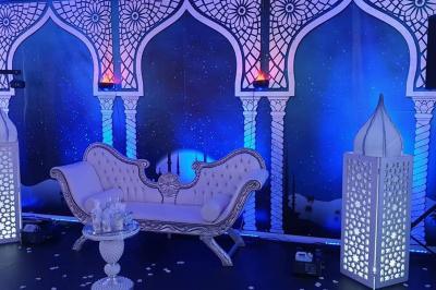 Miniature Sable d'Orient Déco Event #2 Salle de réception décorée avec des tables élégantes, nappes blanches, centres de table lumineux et plumes blanches.