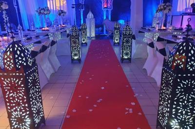 Miniature Sable d'Orient Déco Event #14 Salle de réception décorée avec des tables élégantes, nappes blanches, centres de table lumineux et plumes blanches.