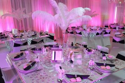 Miniature Sable d'Orient Déco Event #18 Salle de réception décorée avec des tables élégantes, nappes blanches, centres de table lumineux et plumes blanches.