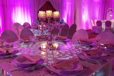 Miniature Sable d'Orient Déco Event #19 Salle de réception décorée avec des tables élégantes, nappes blanches, centres de table lumineux et plumes blanches.