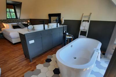 Miniature Location salle Namur (Namur) - La Bergerie de Lives #17 Chambre avec lit double, baignoire îlot, parquet, carrelage hexagonal et échelle porte-serviettes.