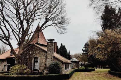 Chambre avec lit double, baignoire îlot, parquet, carrelage hexagonal et échelle porte-serviettes.