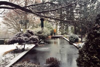 Chambre avec lit double, baignoire îlot, parquet, carrelage hexagonal et échelle porte-serviettes.
