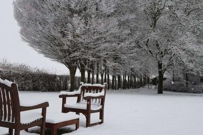 Chambre avec lit double, baignoire îlot, parquet, carrelage hexagonal et échelle porte-serviettes.