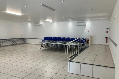 Miniature Salle de réception Plan d’un bâtiment avec disposition des pièces, entrées, parking et espaces extérieurs indiqués.
