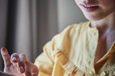 Un grand groupe de personnes souriantes levant les bras, rassemblées dans un parc pour une célébration.