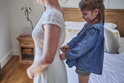 Un grand groupe de personnes souriantes levant les bras, rassemblées dans un parc pour une célébration.