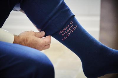 Un grand groupe de personnes souriantes levant les bras, rassemblées dans un parc pour une célébration.