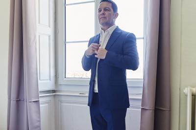 Un grand groupe de personnes souriantes levant les bras, rassemblées dans un parc pour une célébration.