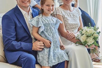 Un grand groupe de personnes souriantes levant les bras, rassemblées dans un parc pour une célébration.