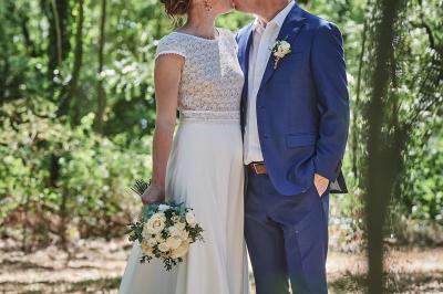 Un grand groupe de personnes souriantes levant les bras, rassemblées dans un parc pour une célébration.