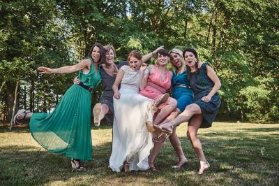 Un grand groupe de personnes souriantes levant les bras, rassemblées dans un parc pour une célébration.